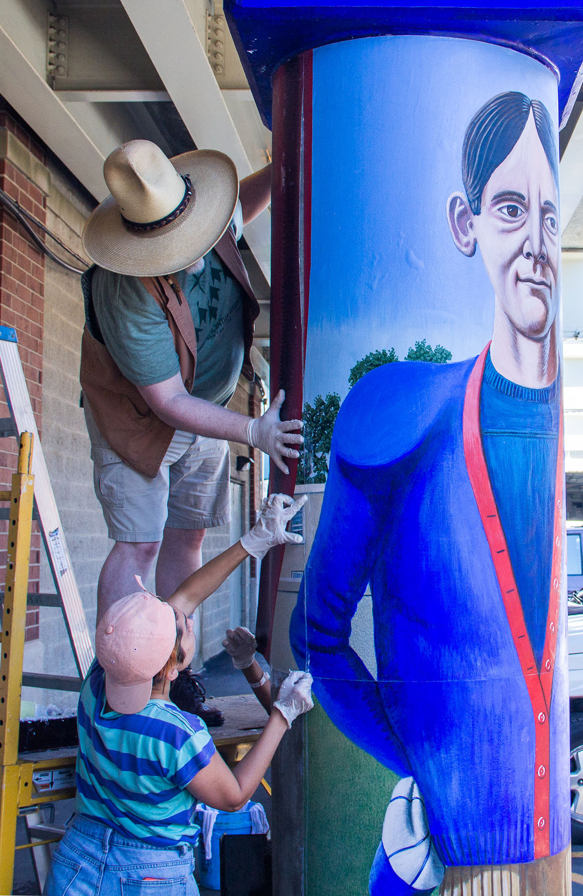 Brother Mark Elder, C.M.,works with students to add four new murals last summer. One of the new pillars recalls the "D-Men," from which the nickname "Blue Demons" emerged. (DePaul University/Russell Dorn)